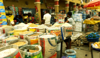Traders selling garri, maize and beans at a Lagos market, one of the food items that have become cheaper in Nigeria