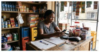 Nigerian retail seller reviewing insurance policy details on a phone